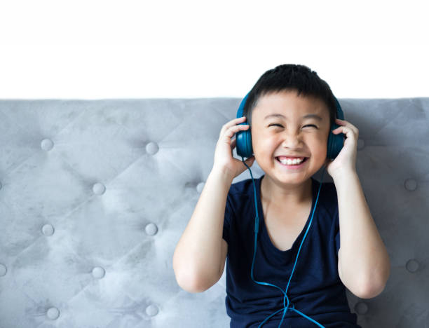 Little boy listening to music on bed at bedroom for relax stock photo