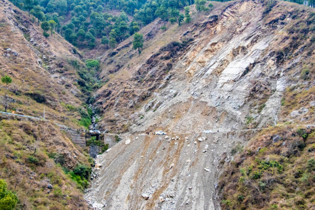 Photo of Mountain landslide in an environmentally hazardous area blocking road.