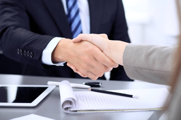 istock Business People shaking hands, finishing up a meeting in office, unknown human group 1127091380