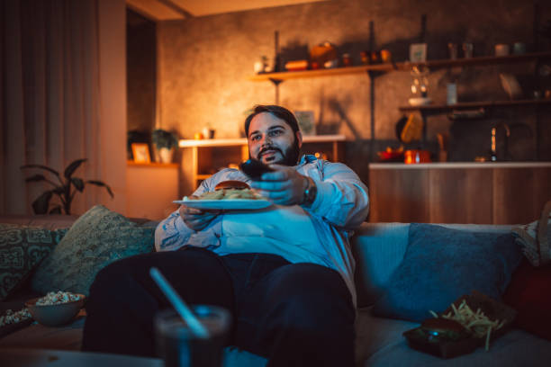 istock Fat man eating fast food 1127093729
