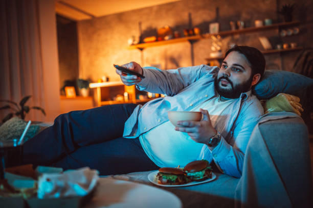 istock Fat man eating fast food 1127093828