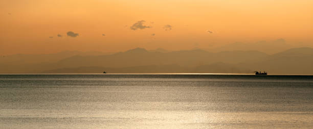 istock Panoramic view of ship at sunset with mountains 1127094903