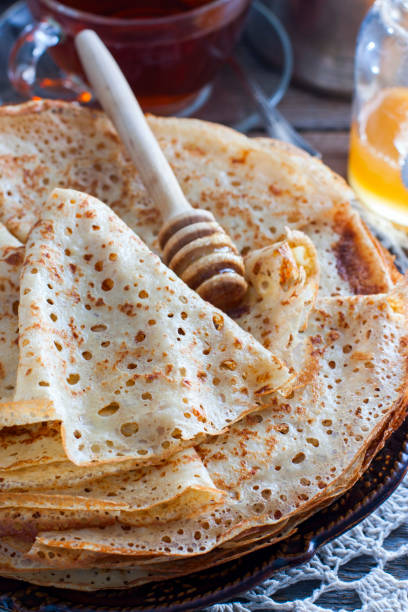 istock Homemade thin pancakes on a wooden table with honey, selective focus 1127095247