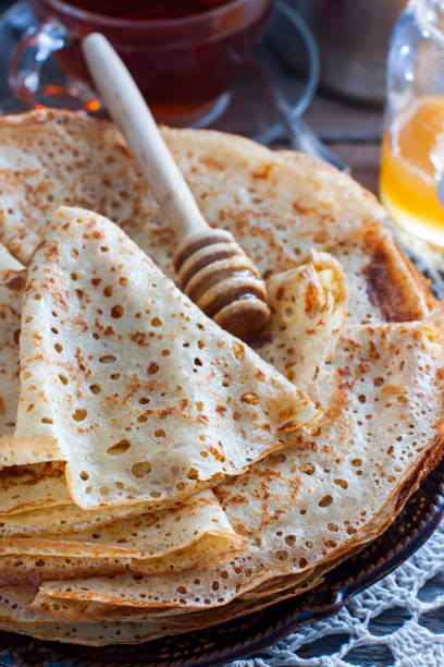 istock Homemade thin pancakes on a wooden table with honey, selective focus 1127095264