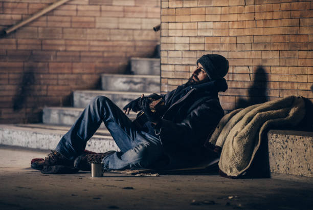 istock Homeless man playing guitar in underpass tunnel 1127095889