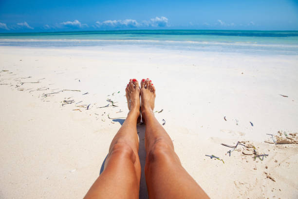 istock Female legs on sandy beach - personal perspective 1127097099