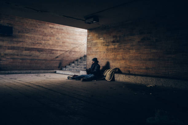 istock Homeless man playing guitar in underpass tunnel 1127097397