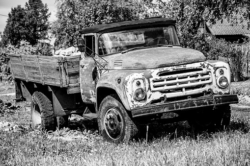 Old abandoned rusty grunge car with bricks in its truck body