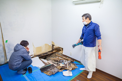 Two constructions worker are discussing about the broken floor.