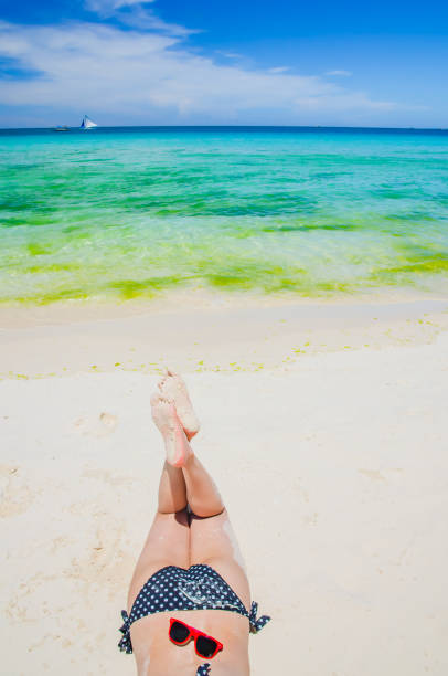 istock Young woman lying down on the beach 1127102629