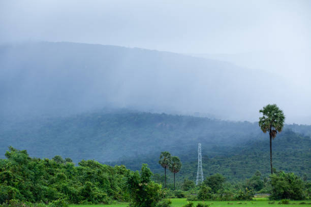 Scenic rural landscape of Kampot, South Cambodia. It's raining over the mountain and paddy field, power line pylon in mountainous area. Scenic rural landscape of Kampot, South Cambodia. It's raining over the mountain and paddy field, power line pylon in mountainous area. Rainy season. kampot stock pictures, royalty-free photos & images