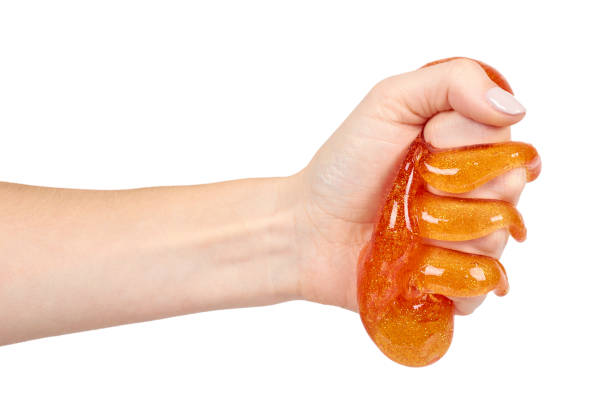 istock kid playing orange slime with hand, transparent toy 1127104963