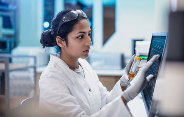 mujer científico trabajando en el laboratorio, utilizando la pantalla de la computadora - bioquímica fotografías e imágenes de stock