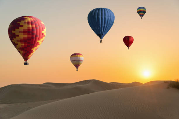 istock Sunset in desert, hot air balloons in sky 1127107925