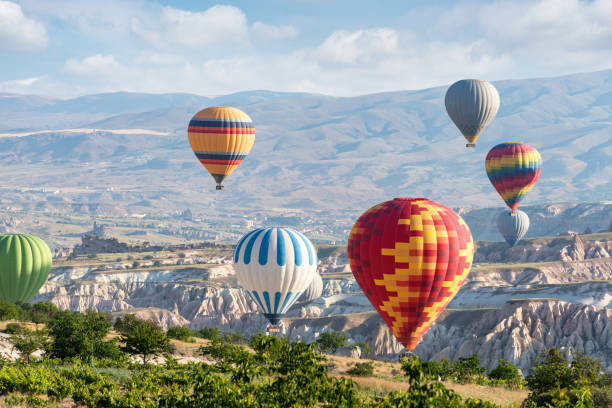 istock Hot air balloons flying over mountains 1127107969