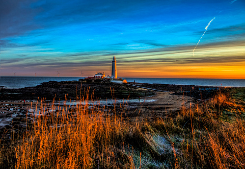 Whitley Bay, England - January 21, 2019: Dawn creeps up on the lighthouse on St. Mary's Island off the coast of Whitley bay, in the far North of England.