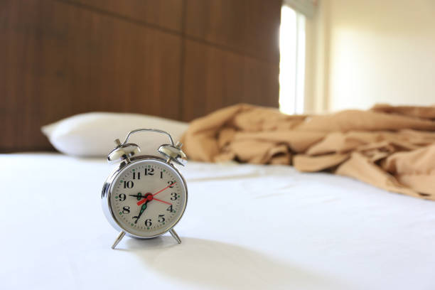 istock Old alarm clock on bed in bedroom 1127109951