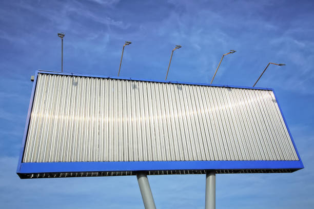 Blank stationary metal billboard for outdoor advertising against a blue sky