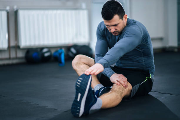 istock Muscular man stretching his legs before workout. 1127111153