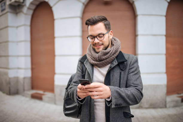 istock Hipster man walking in the city and typing sms. 1127111358