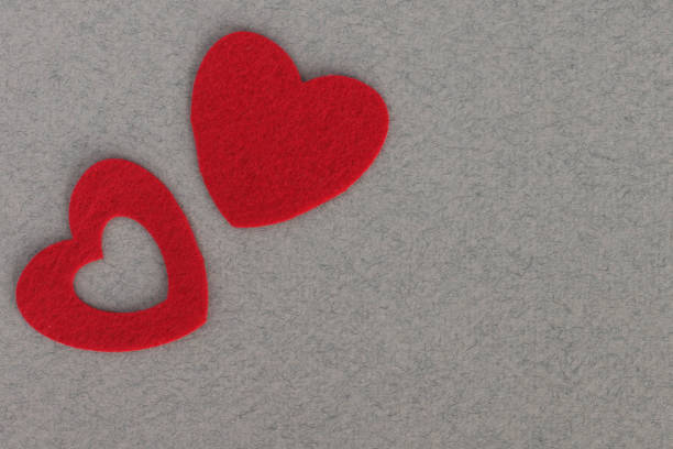 red felt hearts on grey background with place for inscription red felt hearts on grey paper background with space for inscription интерьер помещений stock pictures, royalty-free photos & images