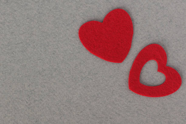 red felt hearts on grey background with place for inscription red felt hearts on grey paper background with space for inscription интерьер помещений stock pictures, royalty-free photos & images