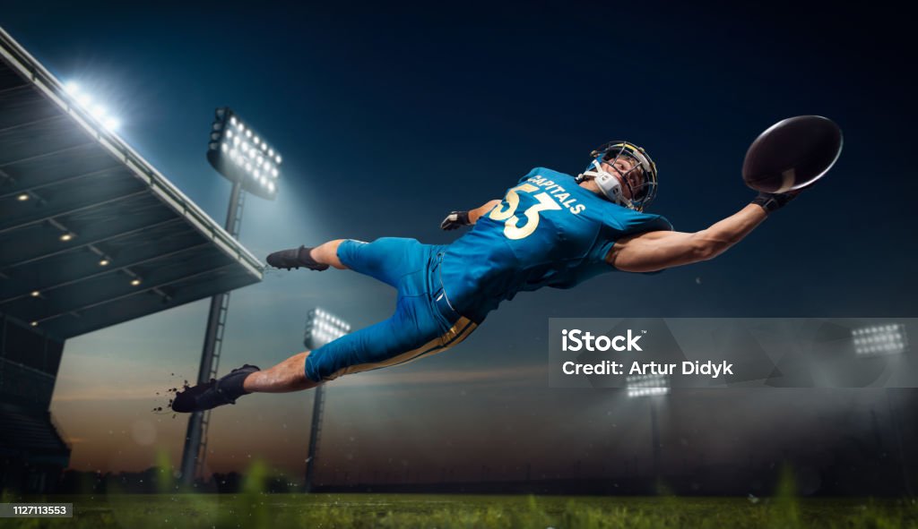 American football American football. American football players in professional sport stadium. American Football - Ball Stock Photo