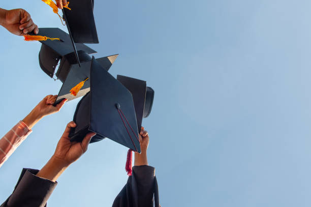 istock Black hat of the graduates floating in the sky. 1127115461