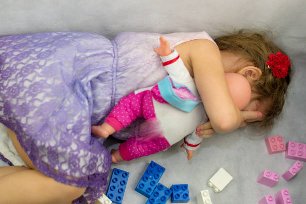 小さな女の子と彼女の赤ん坊の人形 - baby doll dress ストックフォトと画像