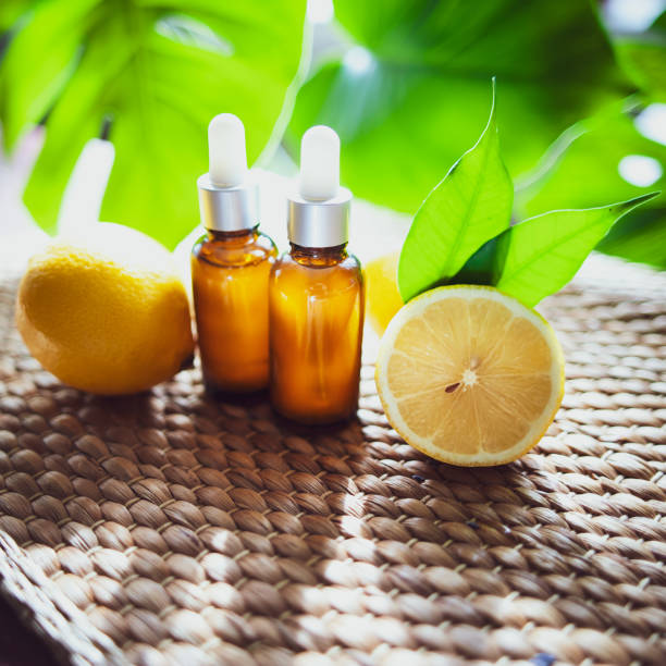 istock Bottles with lemon oil, fresh  fruit whole and half on a natural tropical background. 1127119239