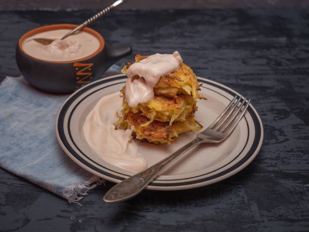 istock Cabbage oladi with sour cream, a cup with stewed sour cream on a dark wooden table, denim napkin, cutlery. 1127122194