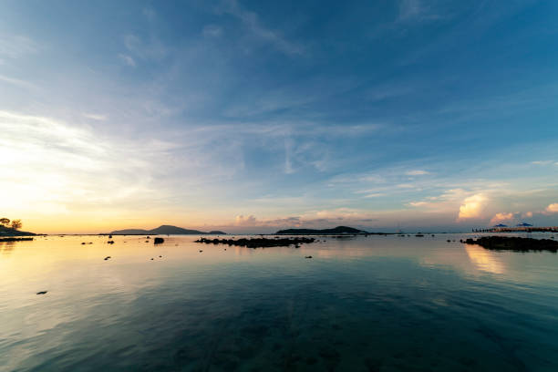 cielo drammatico paesaggio marino con roccia nello scenario dell'alba e bellissimo riflesso nel mare - reflection water rock beach foto e immagini stock