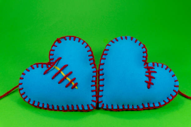 Hand stitched foam sheet blue toy hearts over a colorful green background for romantic, relationship, Valentines Day, broken heart and gays love concept