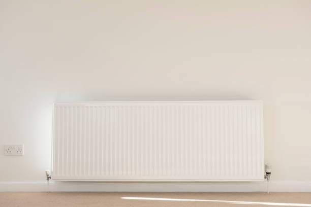 istock One single radiator single white in lounge neutral background carpet and wall for home heating 1127125072