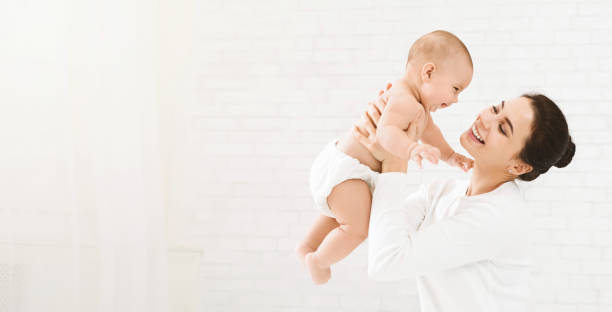 young mom holding her happy baby in air - mother enjoyment built structure human head imagens e fotografias de stock