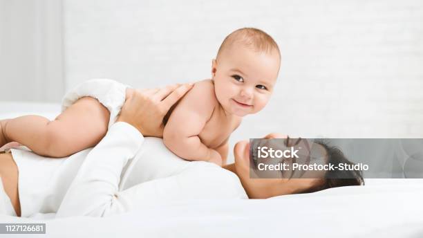 Mamma E Bambino In Pannolino Che Giocano In Camera Da Letto - Fotografie stock e altre immagini di Bebé
