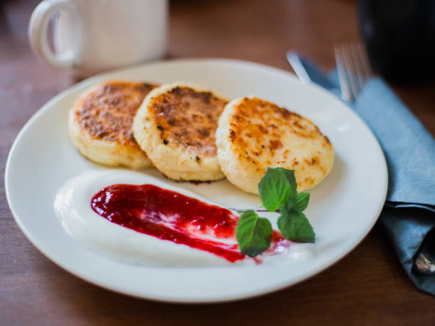 istock sweet cheese pancakes with sour cream on a white plate 1127126707