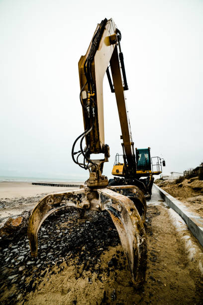 istock Dumper truck and mechanical digger on the beach 1127126929