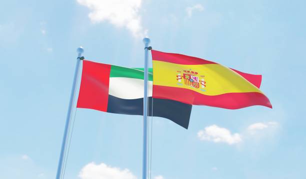 istock Spain and UAE, two flags waving against blue sky 1127128118