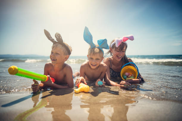 bambini che giocano alla versione da spiaggia della caccia all'uovo di pasqua - china sea foto e immagini stock