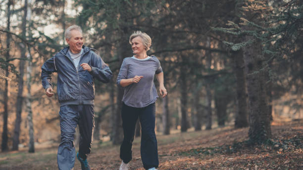 istock Senior couple jogging in a forest 1127129100