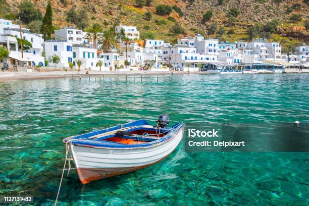 Fishing Boat And The Scenic Village Of Loutro In Crete Greece Stock Photo - Download Image Now