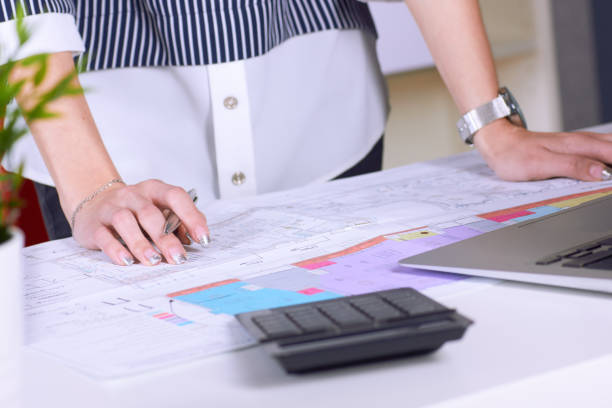 istock Real estate creative studio office. Architect woman working on architectural project for interior design. Woman's hands over the table with the drawing. 1127132125