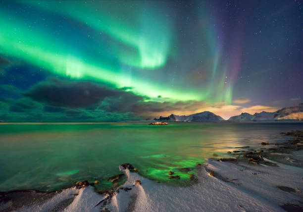 verdadera magia de luces del norte - fiordos noruegos con nieve y montañas - norway lofoten and vesteral islands sea mountain range fotografías e imágenes de stock