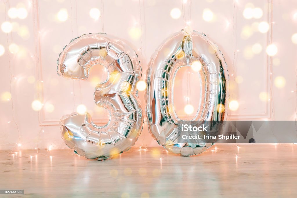 Silver foil birthday balloons number 30 with glitter lights. Silver foil birthday balloons number 30 with glitter lights. Birthday concept. Number 30 Stock Photo