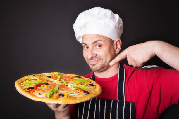 Retrato de feliz atractivo cocinero con una pizza - foto de stock