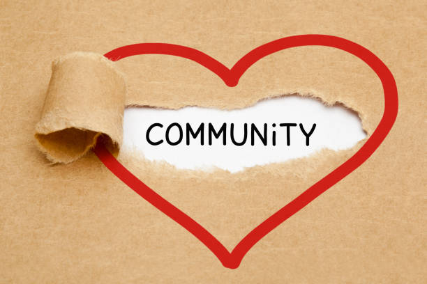 Community Ripped Heart Paper Concept Handwritten word Community appearing behind torn red heart on brown paper. non profit organization photos stock pictures, royalty-free photos & images