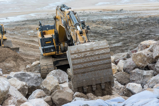 istock Dumper truck and mechanical digger on the beach 1127135787