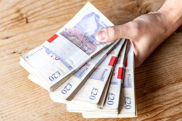 primo del rovescio dei pacchetti di banconote da £ 20 consegnati - focus on foreground tax close up finance foto e immagini stock