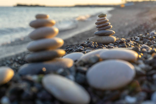 istock Stones pyramid on pebble beach symbolizing stability, zen, harmony, balance. Shallow depth of field. 1127138380